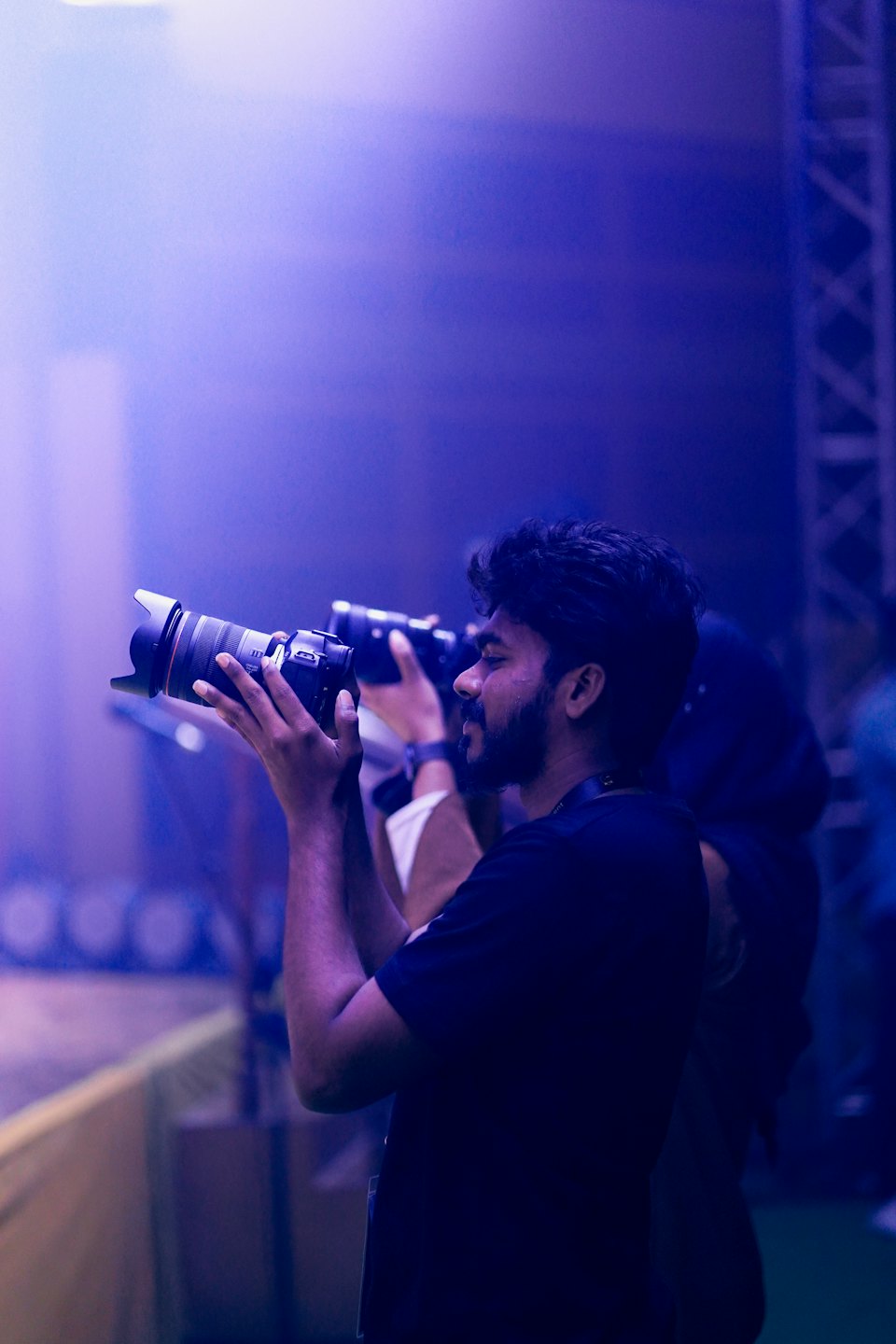 Photographer takes pictures with a telephoto lens at an event.